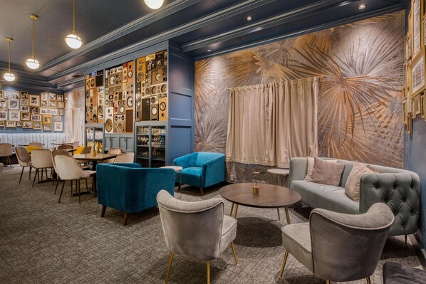 A modern lounge area with plush seating, a wall adorned with vintage audio equipment, and a decorative mural. - Best Western Portland West Beaverton (Portland)