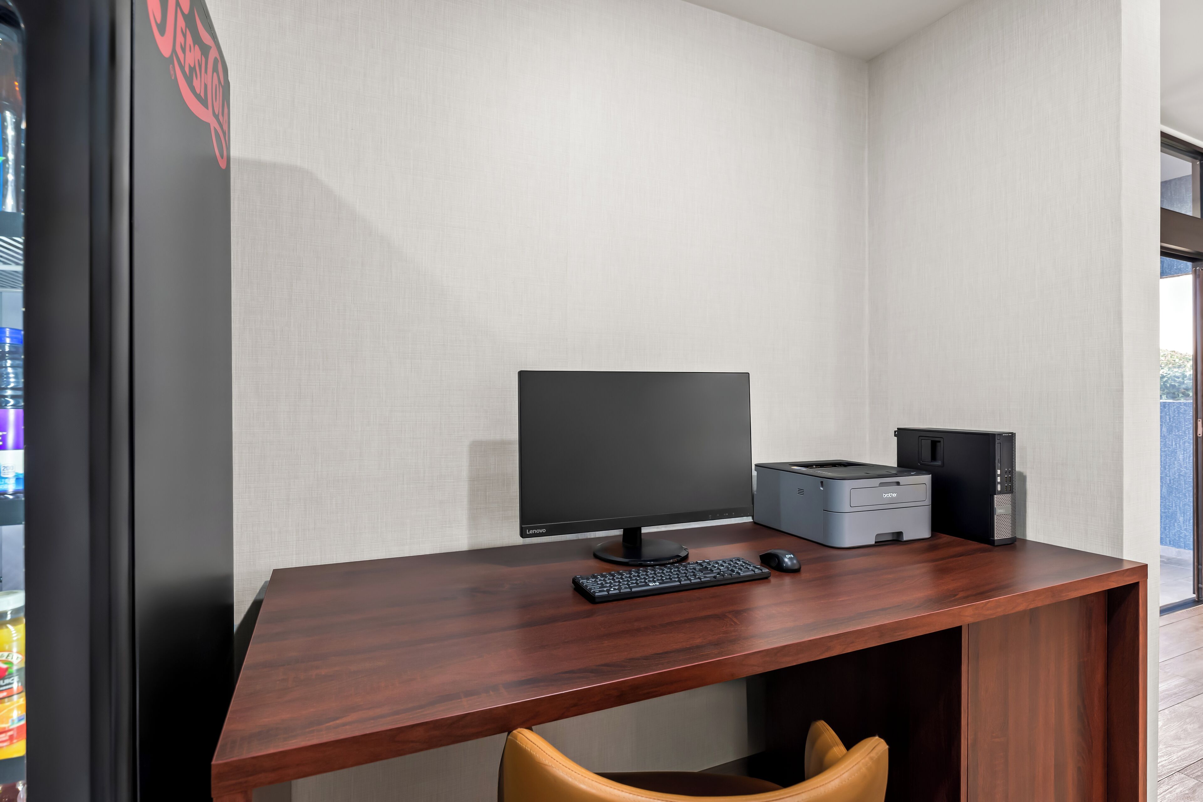 Un escritorio moderno con monitor de computadora, teclado e impresora.