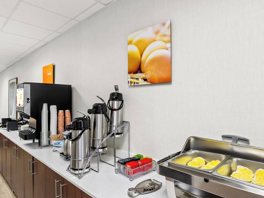 En buffé med kaffemaskiner, ett bord med frukt och en kaffestation.