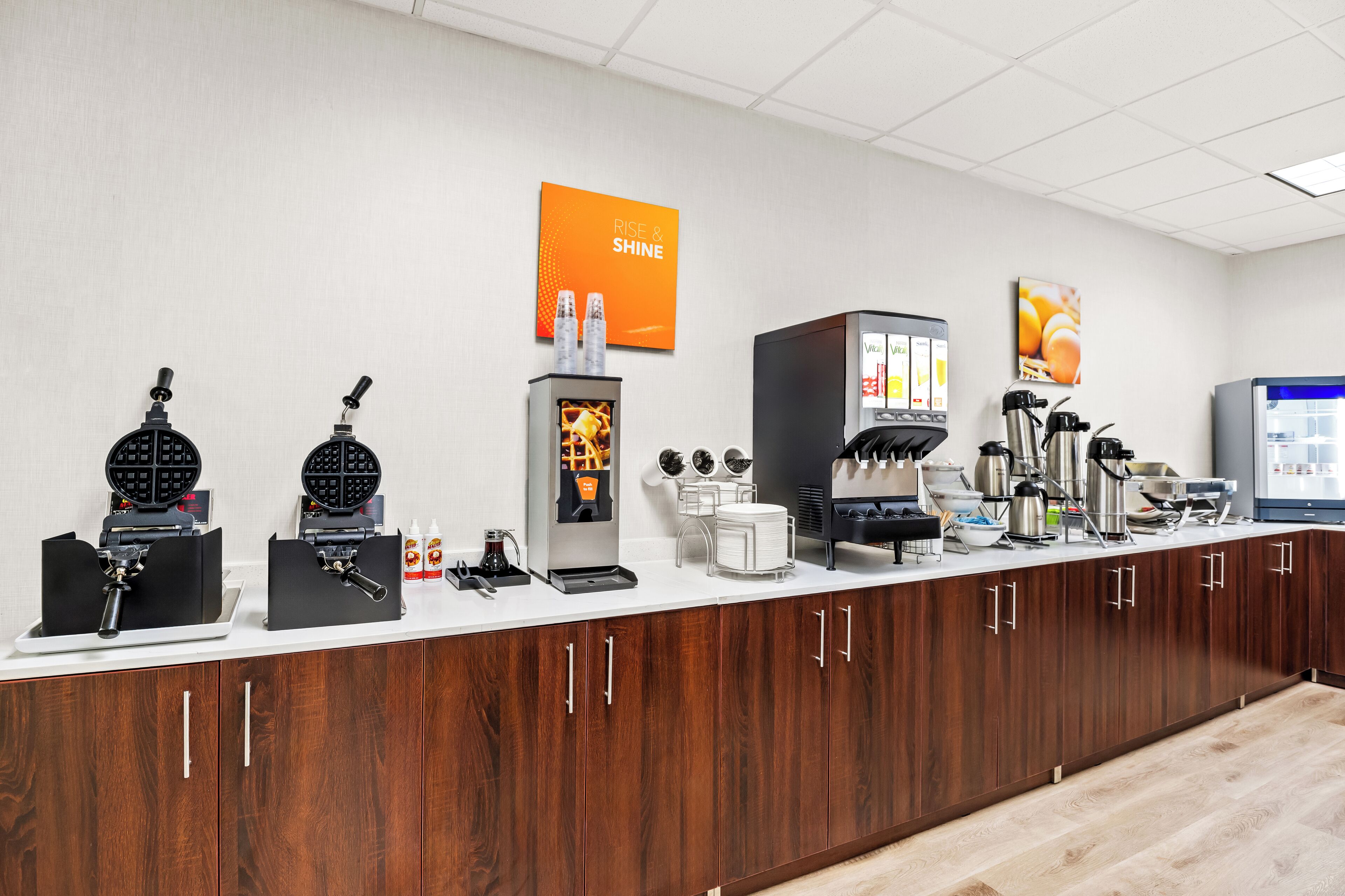 Un coin cuisine équipé d’un appareil à gaufres, d’une machine à café et d’un réfrigérateur.