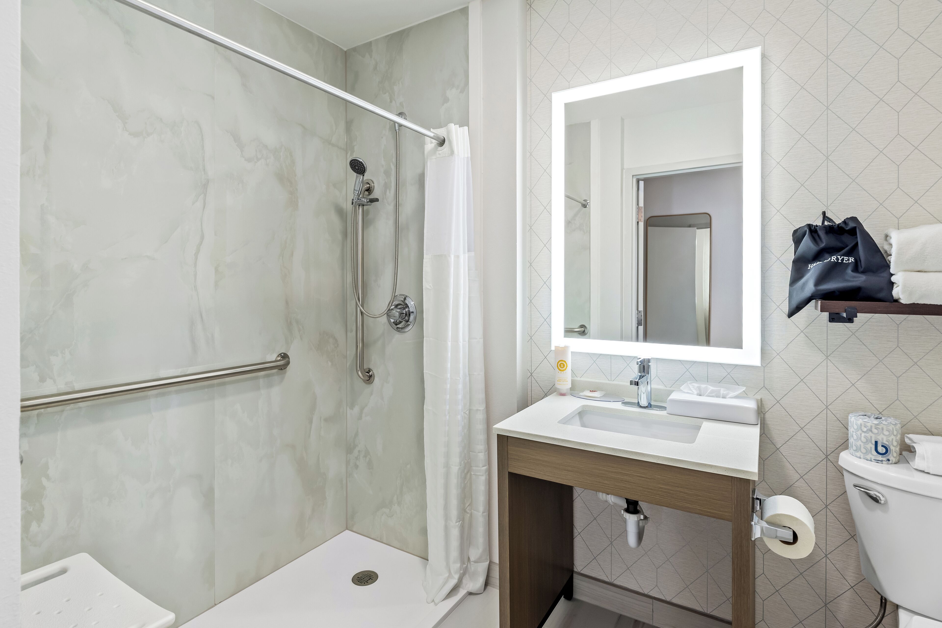 A modern bathroom with a shower, toilet, and sink.