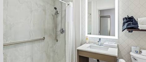 A modern bathroom with a shower, toilet, and sink.