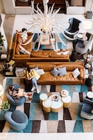 Ein stilvoller Lounge-Bereich mit Ledersofas, runden Tischen und einer markanten Leuchte.