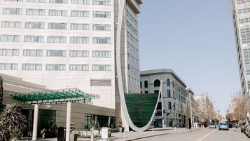 Un edificio moderno con entrada cubierta y una estructura verde distintiva.