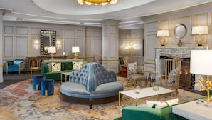 A luxurious living room with a green sofa, a round armchair, and a fireplace. - The Alexandrian Old Town Alexandria, Autograph Collection (Alexandria)