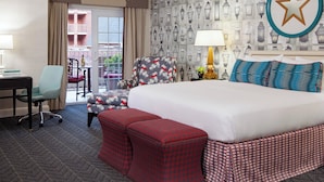 A hotel room with a large bed, a desk, a chair, and a balcony with a view. - The Alexandrian Old Town Alexandria, Autograph Collection (Alexandria)