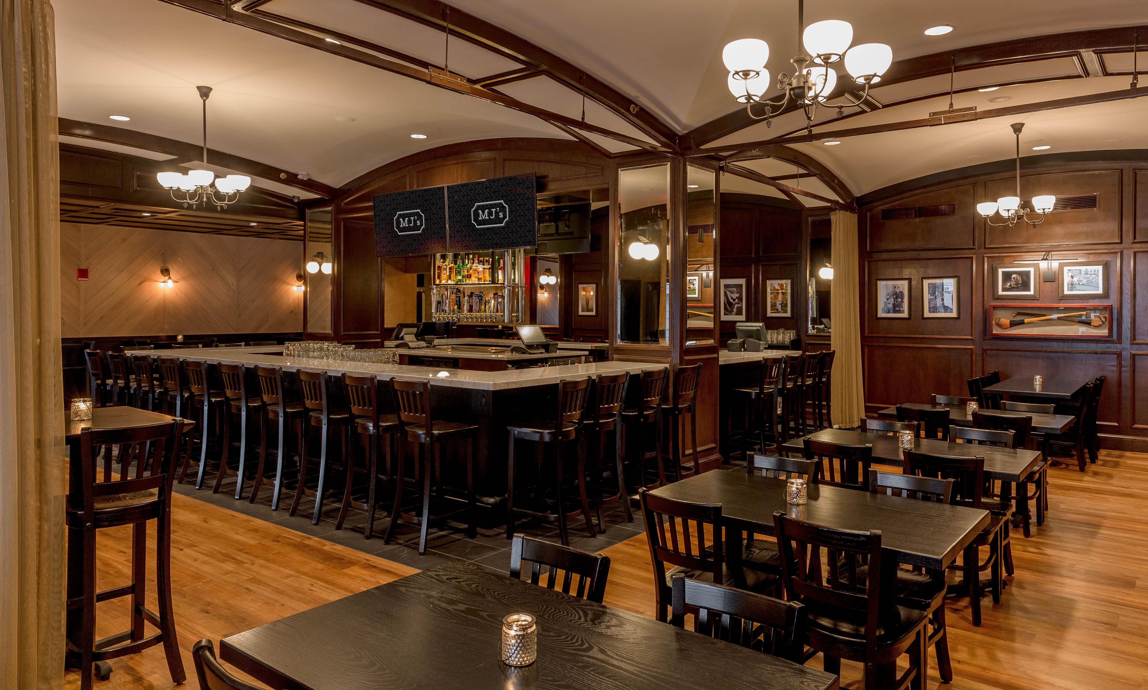 A bar area with a counter, bar stools, and a seating area with tables and chairs.