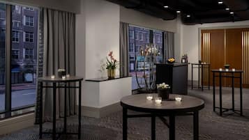 A hotel lobby with large windows, a reception desk, and a bar area.