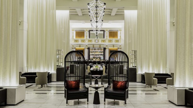 Eine geräumige Lobby mit einer zentralen Sitzecke, einer Bar und einem Chandelier.