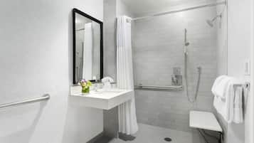 A modern bathroom with a white sink, mirror, and shower.
