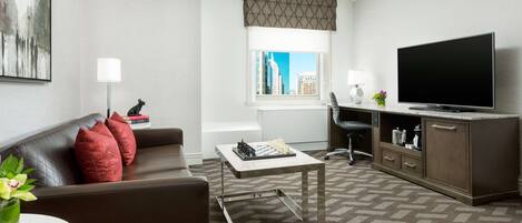 A modern living room with a sofa, coffee table, and a flat-screen TV.
