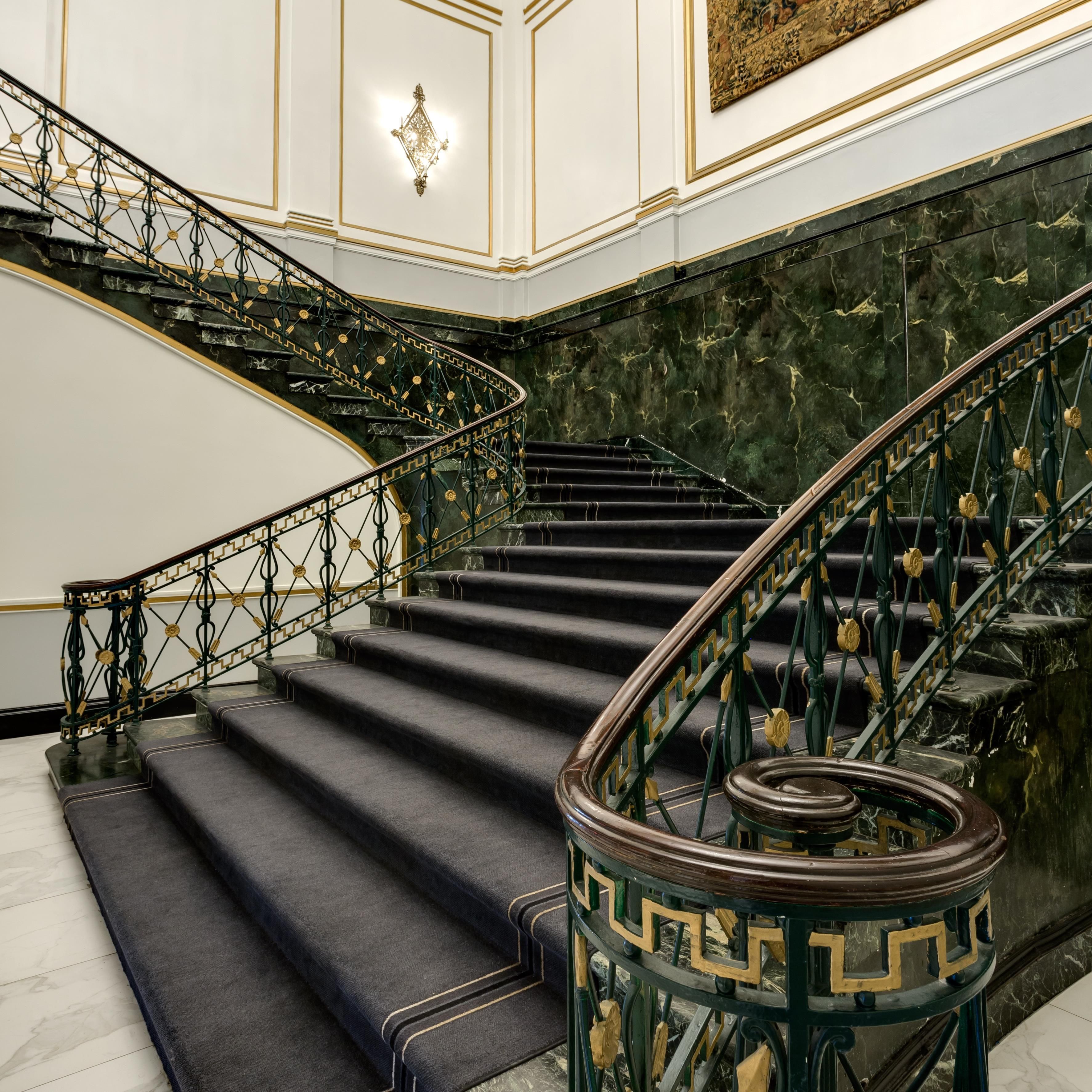 A grand staircase with ornate metal railings and marble steps.