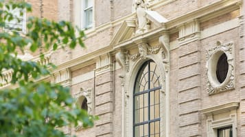 Un edificio con detalles arquitectónicos ornamentales, incluyendo un amplio ventanal de arco y molduras decorativas.