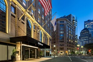 Et hotel i klassisk arkitekturstil, med buede vinduer og et tydeligt amerikansk flag.