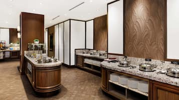 Una cucina moderna in stile hotel, con piani di lavoro in granito, elettrodomestici in acciaio inossidabile e pannelli in legno.