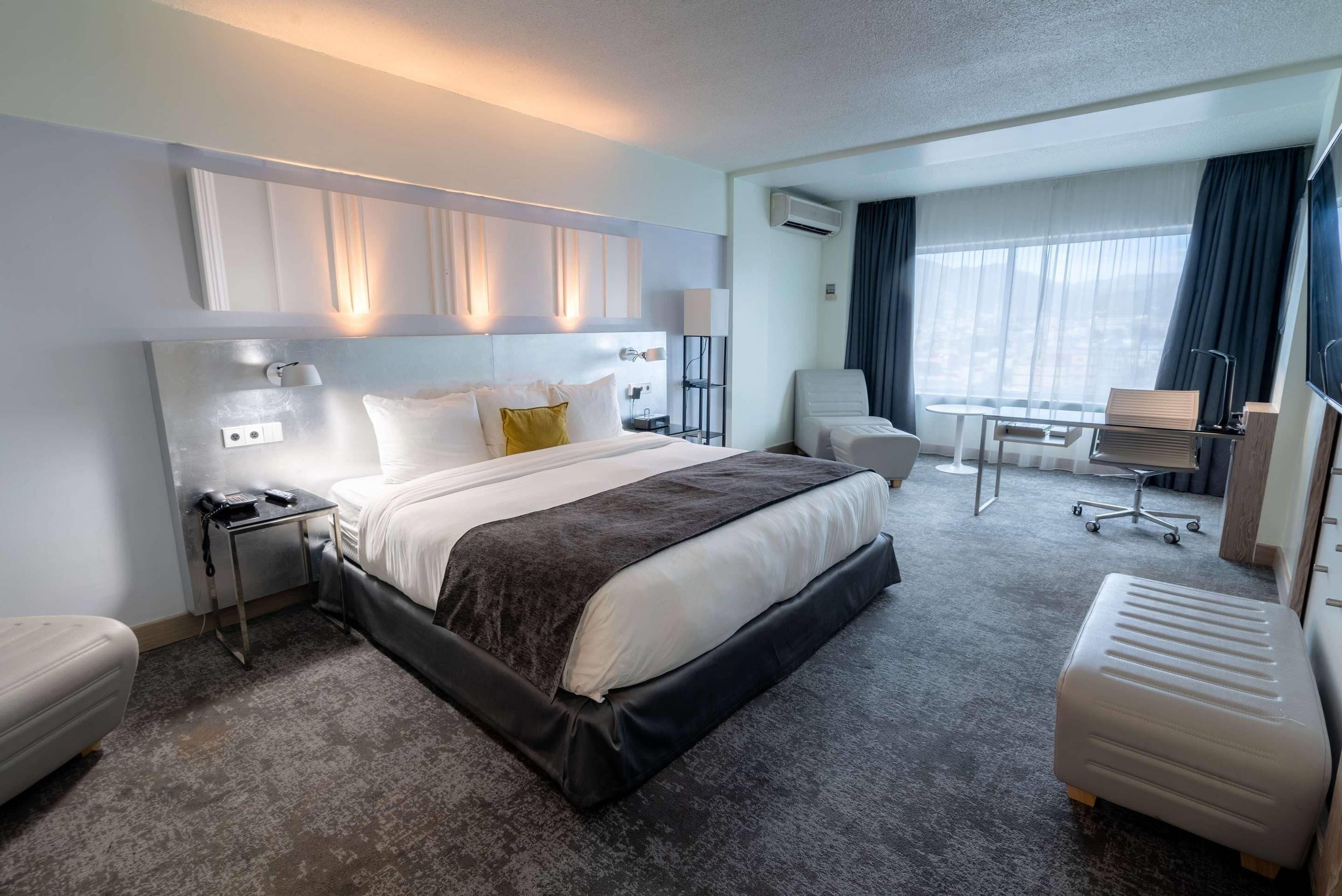 Ropa de cama hipoalergénica y caja de seguridad en la habitación 