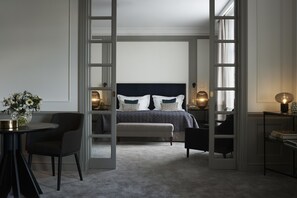A bedroom with a large bed, a bedside table, a chair, and a desk with a lamp. - Grand Hôtel Stockholm (Stockholm)
