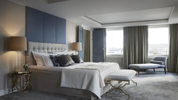 Ett modernt hotellrum med en stor säng, en sittgrupp och utsikt över staden.