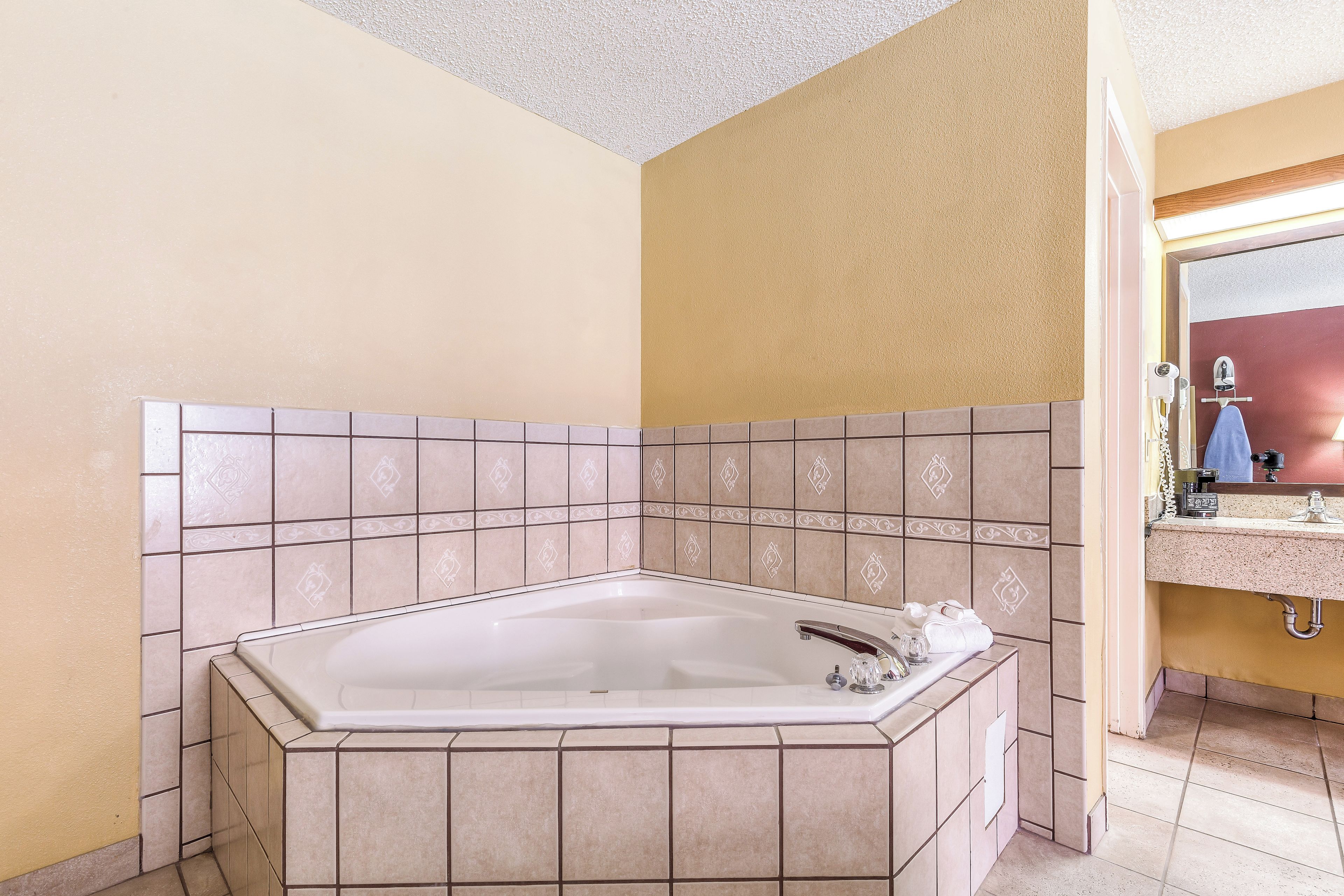 A bathroom with a freestanding bathtub, a vanity with a mirror, and a towel rack.