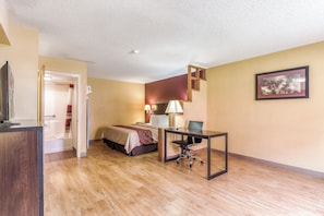A hotel room with a bed, desk, chair, and a television. - Red Roof Inn Amarillo West (Amarillo)