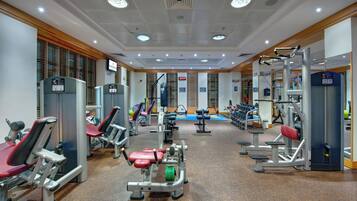 Ein Fitnessstudio mit verschiedenen Trainingsgeräten, darunter Kraftmaschinen und Kurzhanteln.