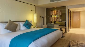 Une chambre d’hôtel avec un grand lit, une table de chevet, une chaise, une petite table et un miroir.