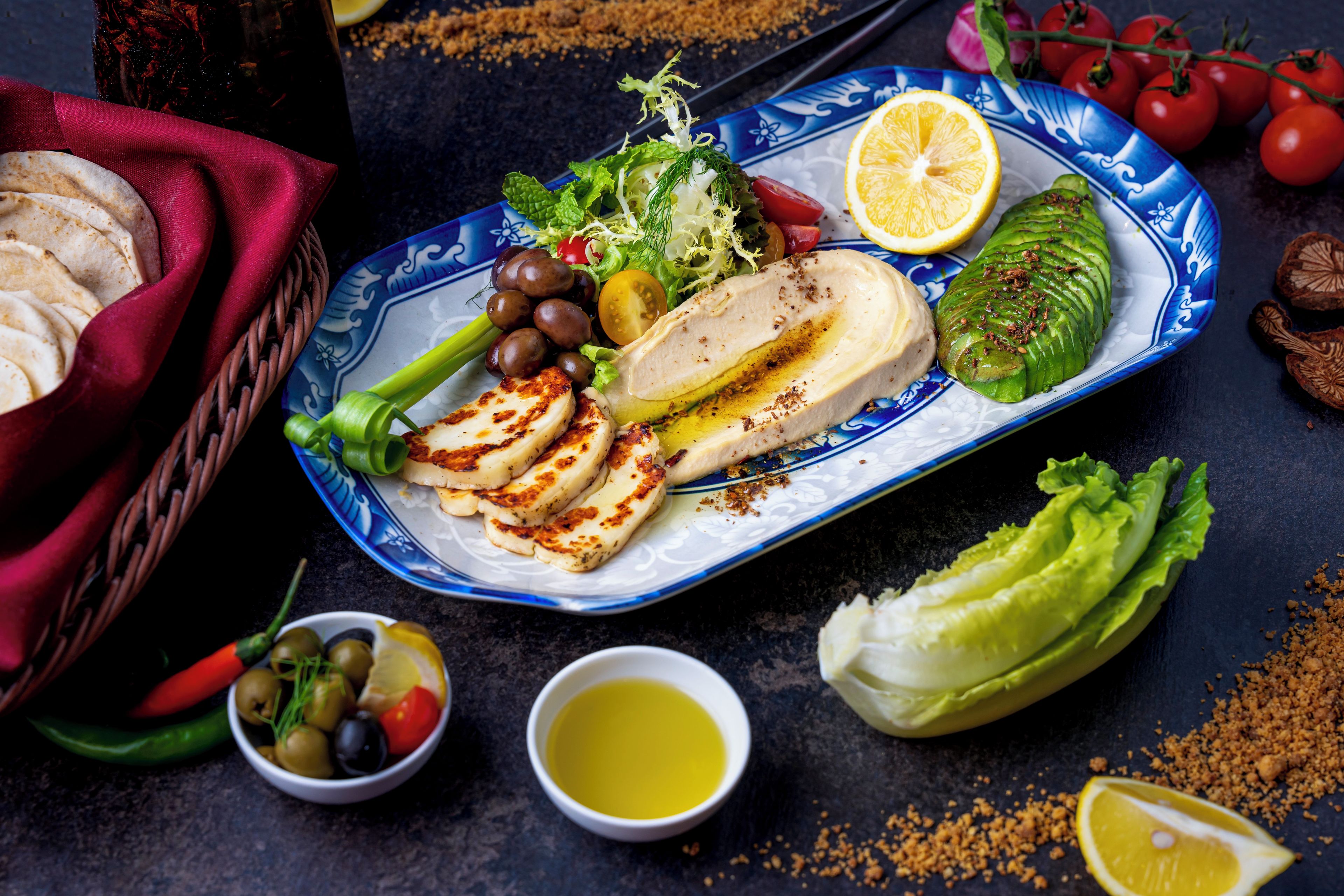 A plate of food with various items including grilled chicken, vegetables, and a lemon wedge.