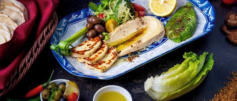 A plate of food with various items including grilled chicken, vegetables, and a lemon wedge.