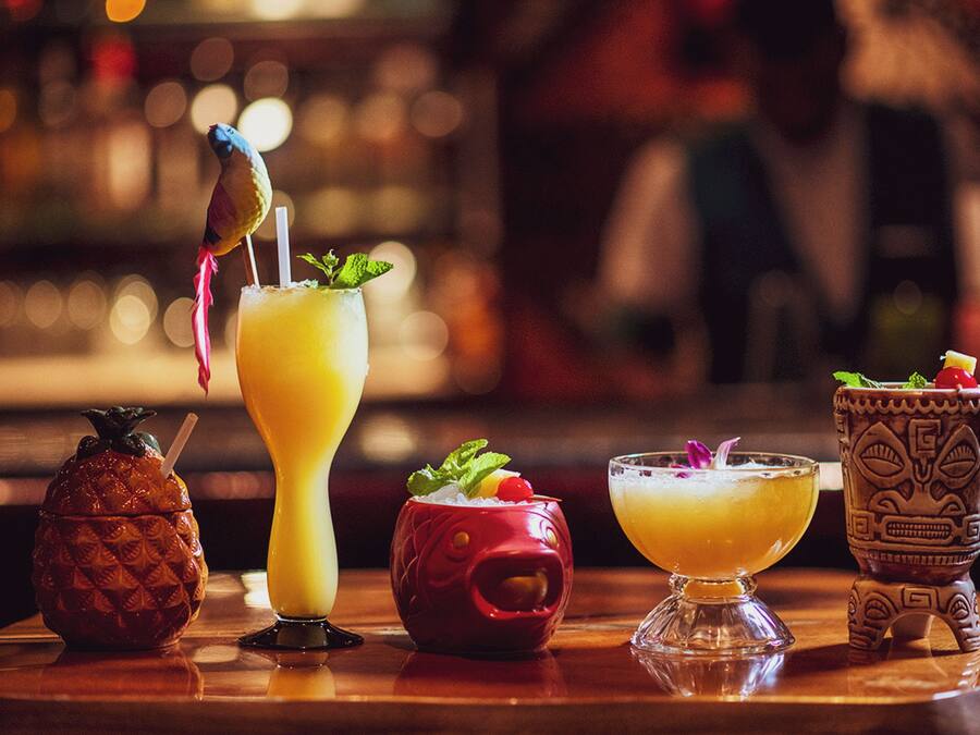 Um bar com diversas bebidas e um pássaro decorativo em um coquetel.