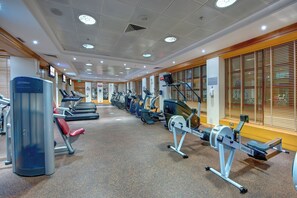 Un gimnasio con cintas de correr, elípticas y máquinas de pesas.