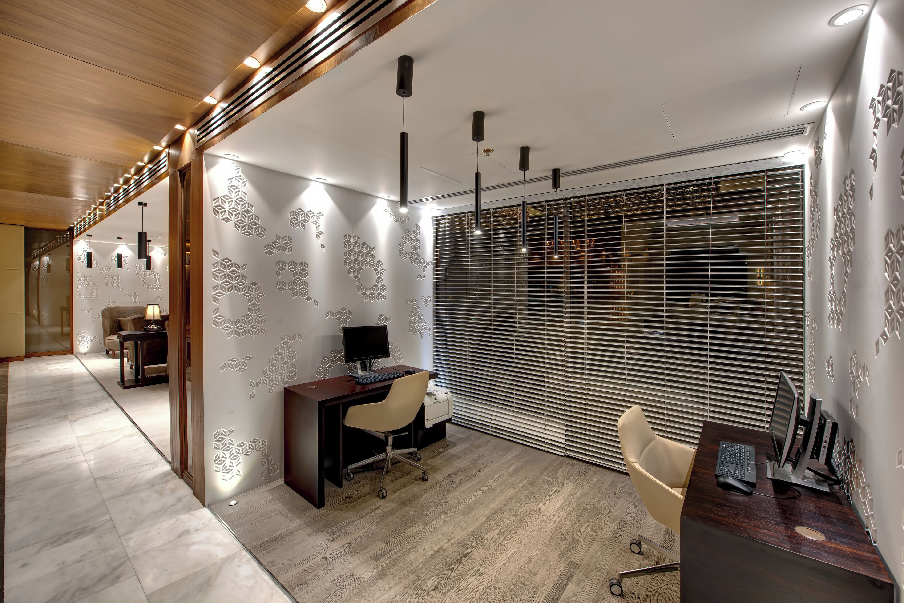 Un espace de bureau moderne comprenant un bureau, une chaise et un ordinateur.