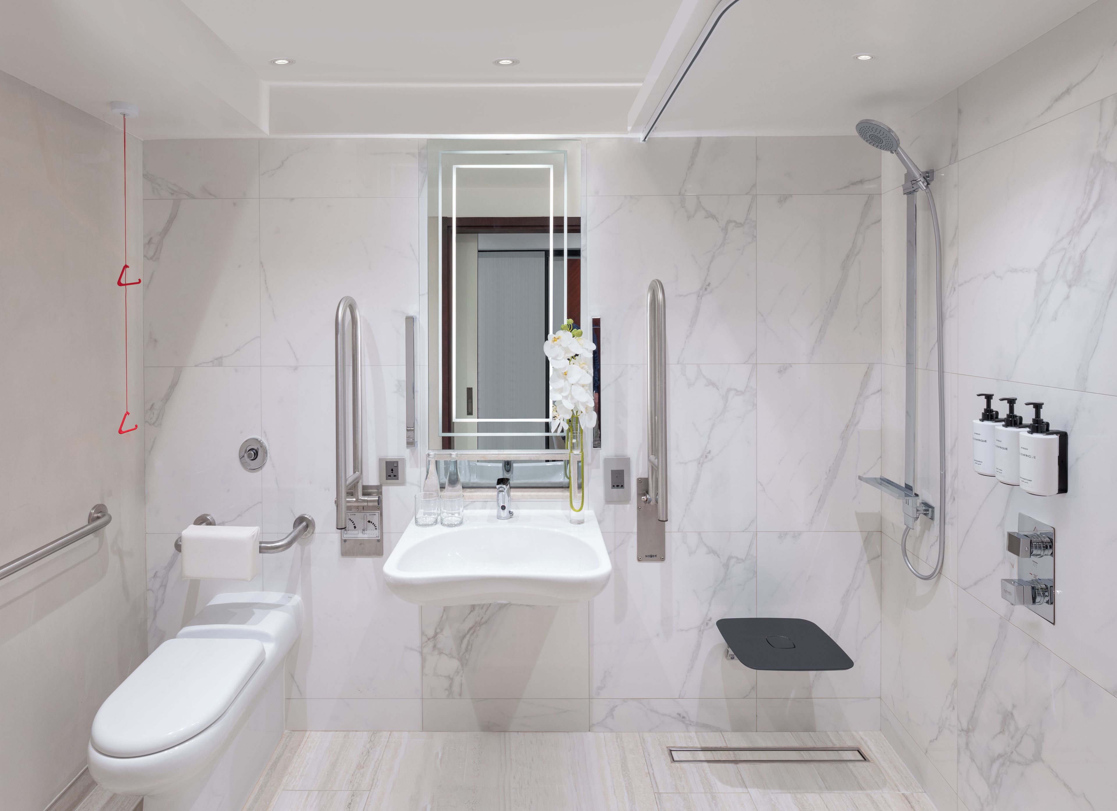 A modern bathroom with a toilet, sink, and shower.