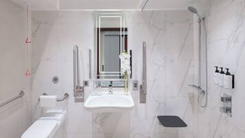 A modern bathroom with a toilet, sink, and shower.