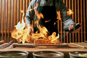 A chef grilling meat over an open flame. - InterContinental Muscat by IHG (Muscat)