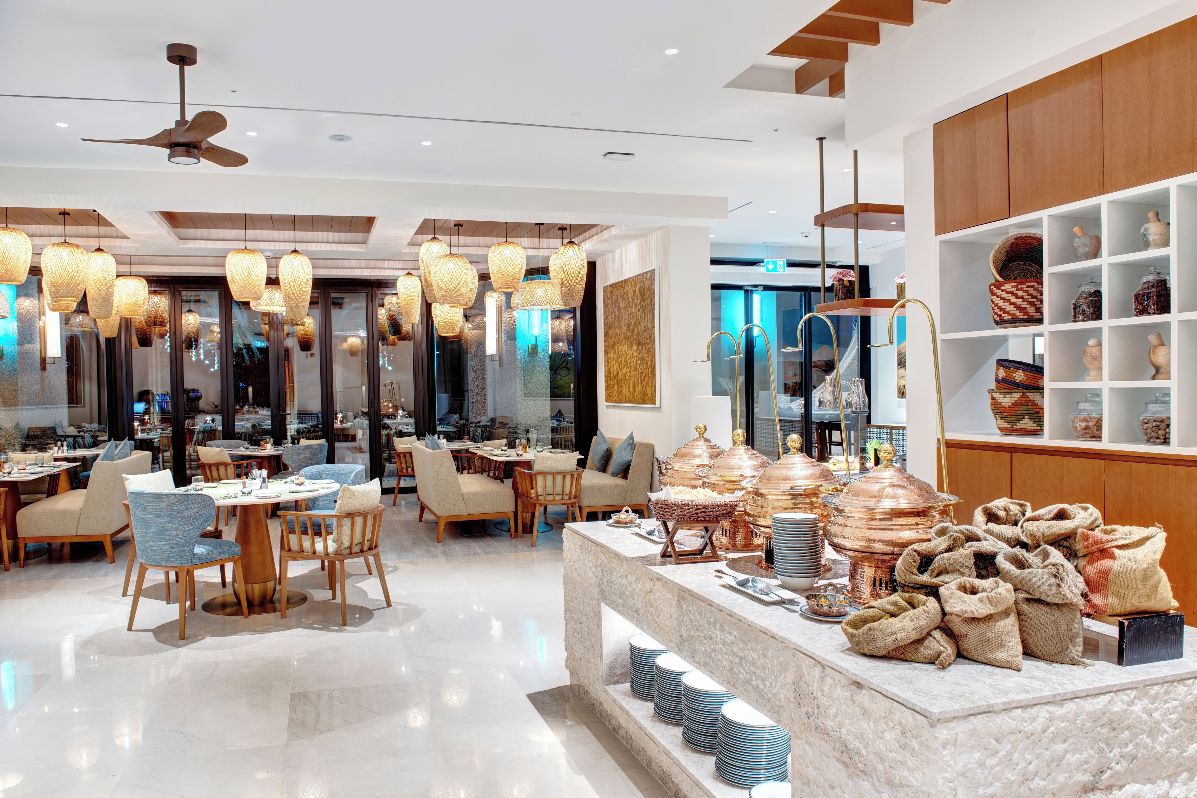 A modern dining area with round tables, chairs, and hanging light fixtures.