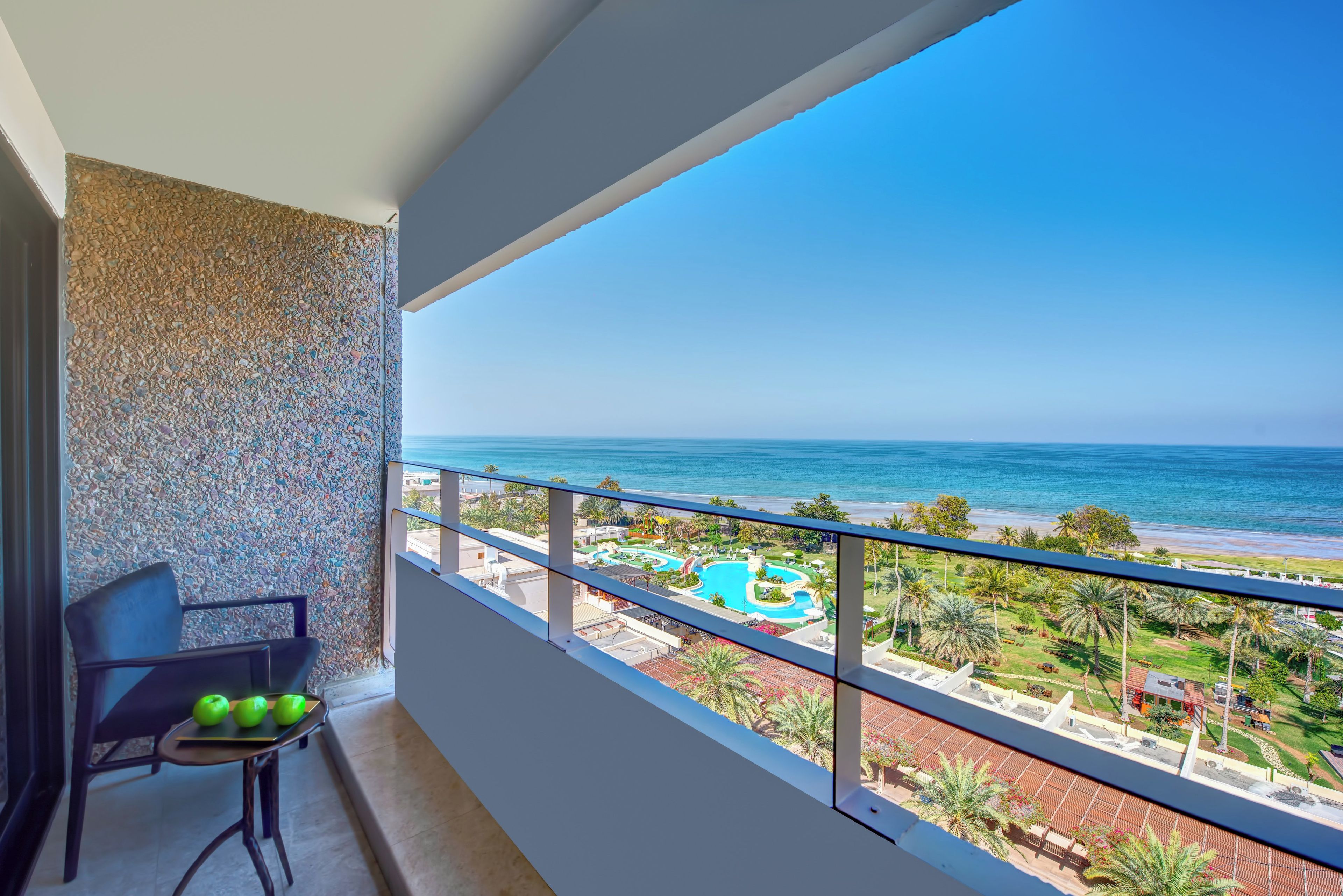 Ein Balkon mit Blick auf Strand und Schwimmbad.