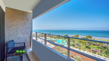Ein Balkon mit Blick auf Strand und Schwimmbad.