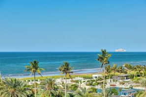 A resort with a pool, palm trees, and a view of the ocean. - InterContinental Muscat by IHG (Muscat)