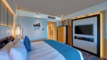 A modern hotel room with a large bed, a flat-screen TV, a wardrobe, and a decorative wall piece.