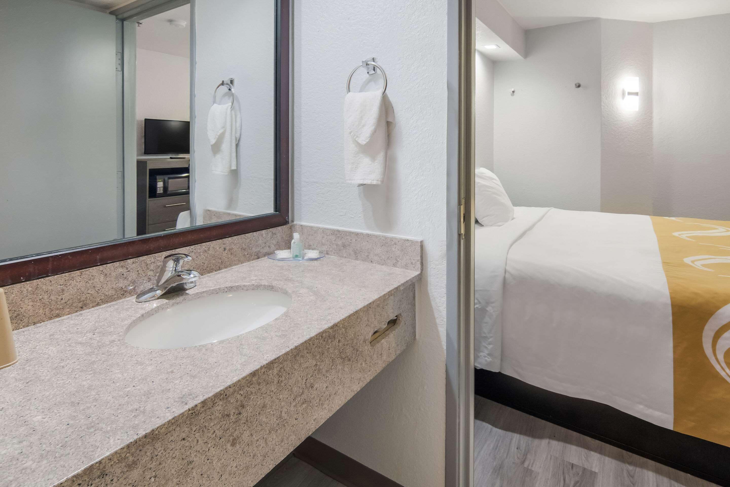 Une salle de bain d’hôtel équipée d’un lavabo, d’un miroir et d’un porte-serviettes.
