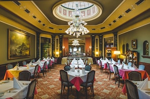 A formal dining room with multiple tables set for service, a grand chandelier, and a large painting on the wall. - Esplanade Hotel Prague (Prague)