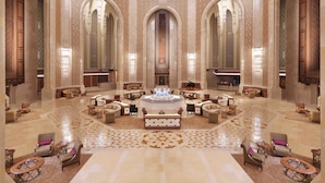 A luxurious lobby with ornate arches, a grand chandelier, and a central fountain. - Al Bustan Palace, a Ritz-Carlton Hotel (Muscat)