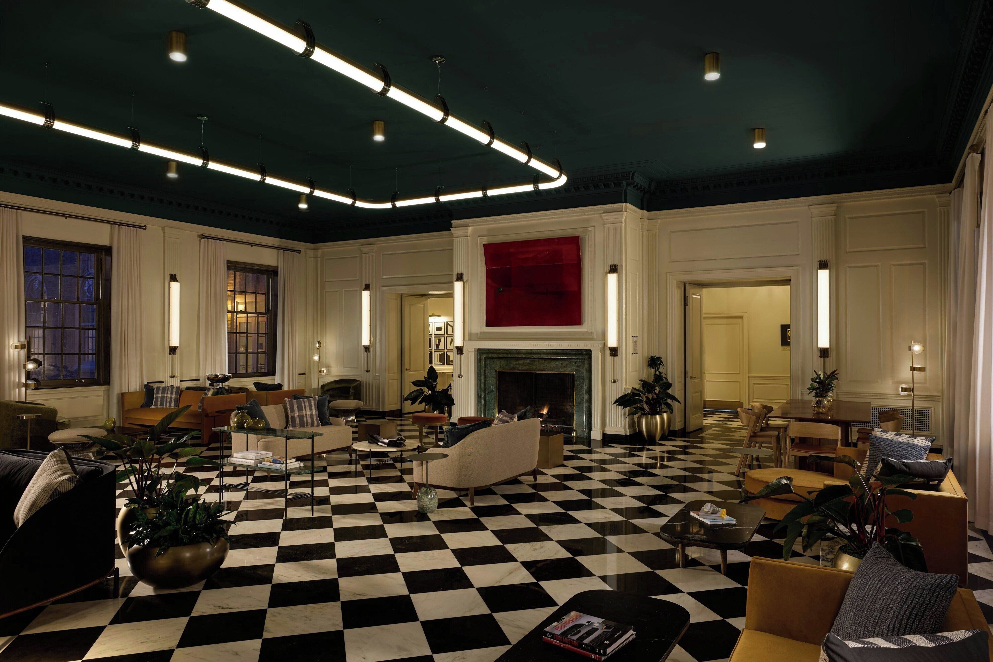 A spacious lobby with a checkered floor, modern lighting, and a fireplace.