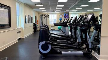 A gym with treadmills, exercise balls, and a mirrored wall.
