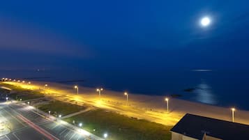 An airport runway at night with airport lights and a moon in the sky.