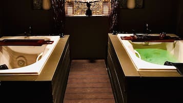 A spa area with two large tubs, a wooden floor, and a caution sign.