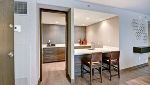 A modern kitchen with a central island, wooden cabinets, and a built-in oven. - Marriott Tulsa Hotel Southern Hills (Tulsa)