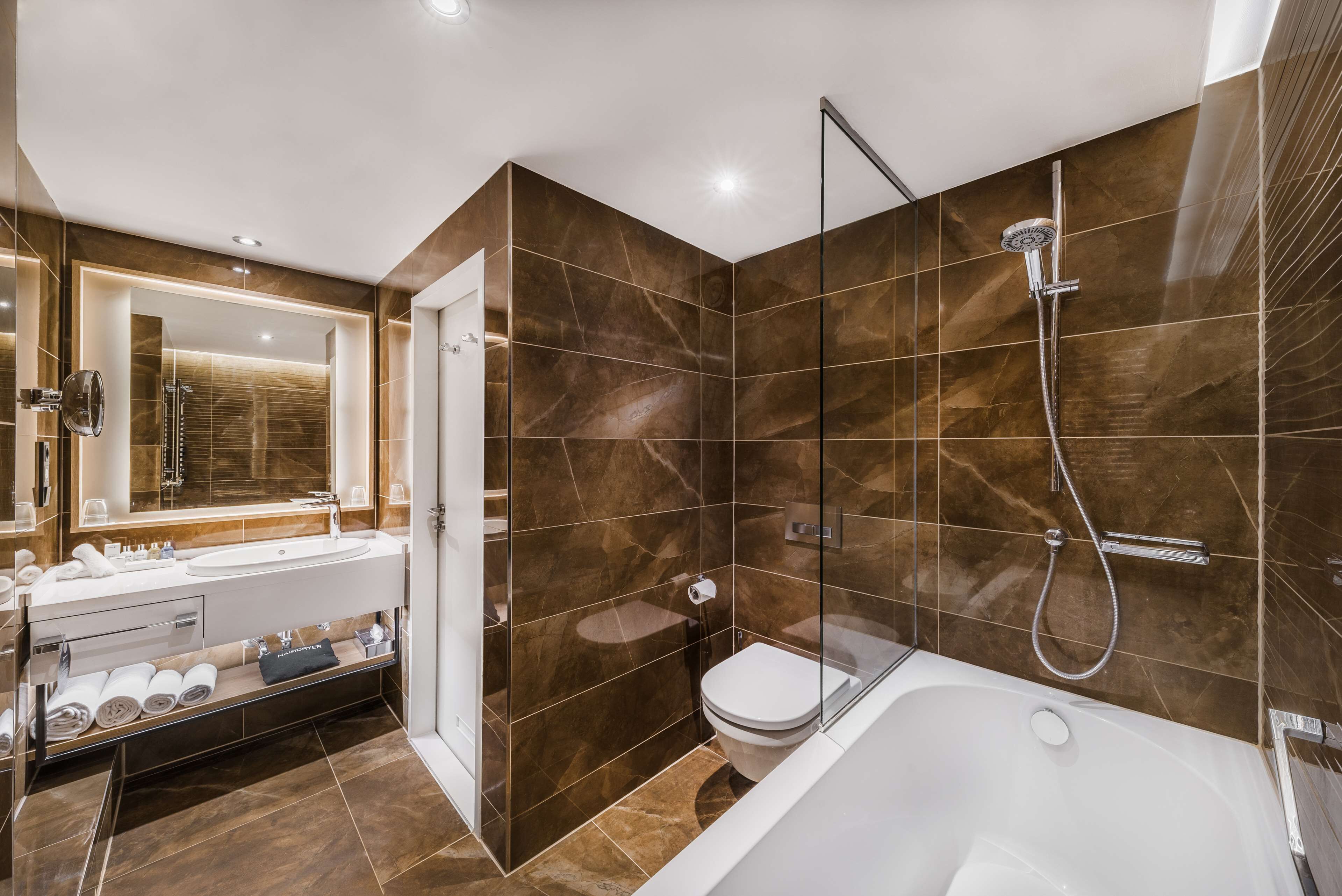 A modern bathroom with a large bathtub, a separate shower area, and a vanity with a mirror and sink.