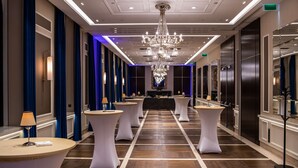 A hotel corridor with round tables, a chandelier, and a mirror on the right wall. - Radisson Blu Beke Hotel, Budapest (Budapest)