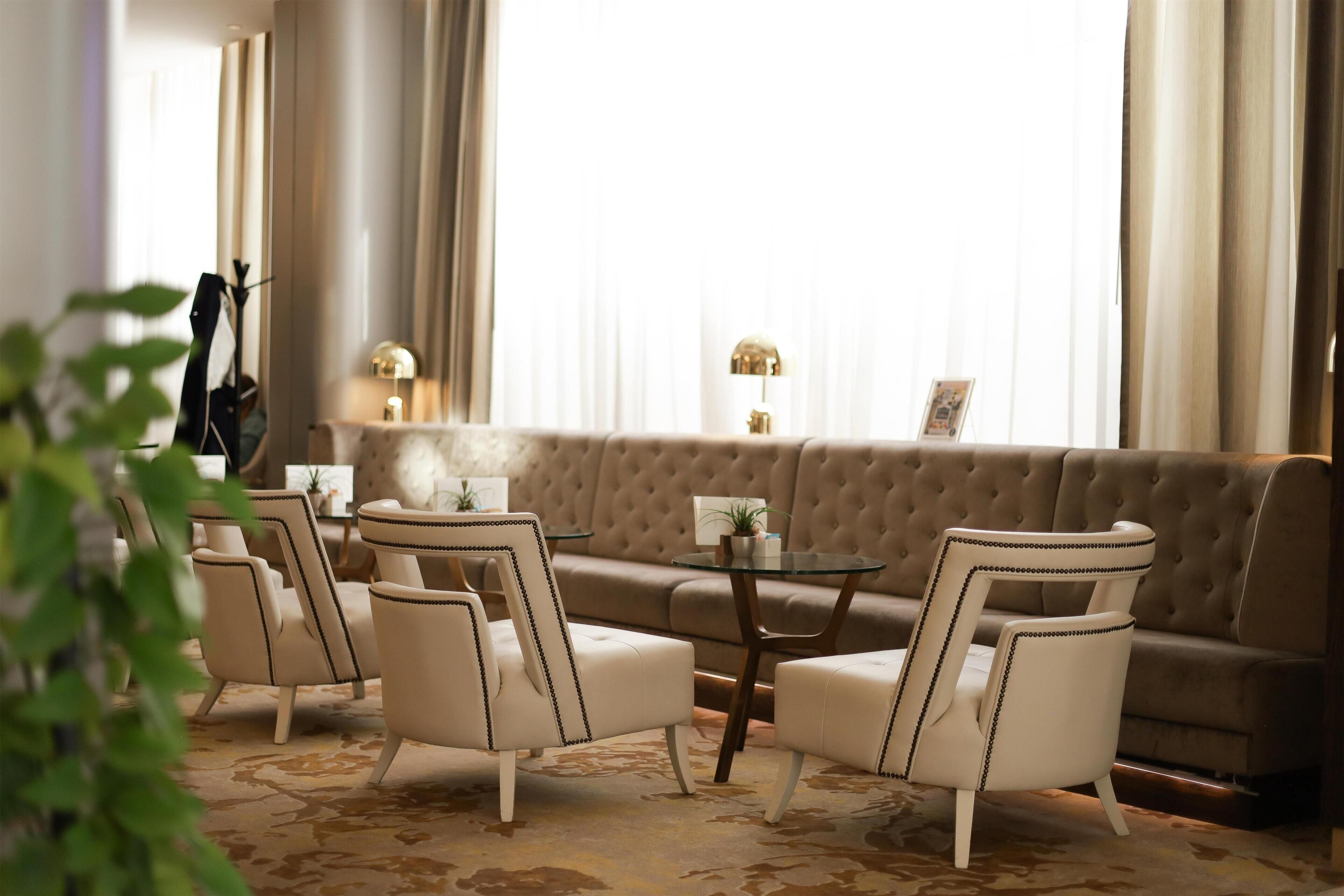 A living room with a sofa, armchairs, a coffee table, and a lamp.
